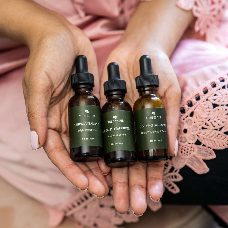 The Tree To Tub Serum Trio on a woman's open palms