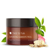 Front of Ginseng Green Tea Eye Cream amber-colored jar with rose petals, green tea leaves and ginseng root slices on its side
