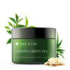   Ginseng Green Tea Face Moisturizer green jar against a white background, with green tea and aloe vera leaves behind it, and slices of ginseng root on the lower right