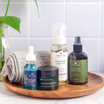 Tree To Tub Vegan Collagen Total Repair Regimen Set, in front of a rolled towel, on top of a wooden tray